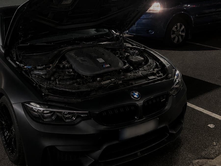 BMW M4 with the bonnet open during a battery replacement in Perth